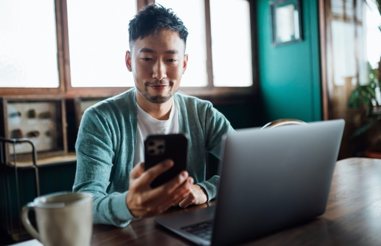 Client reviewing banking and rewards information on a smartphone at a desk.
