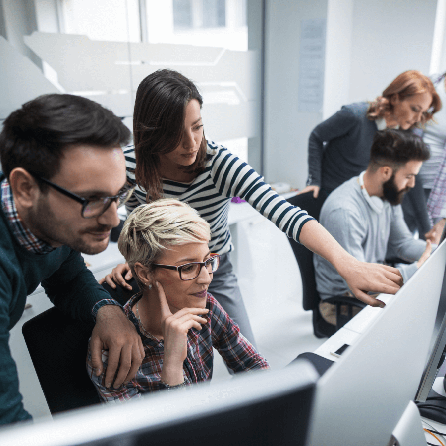 Coworkers reviewing business data together on a computer.
