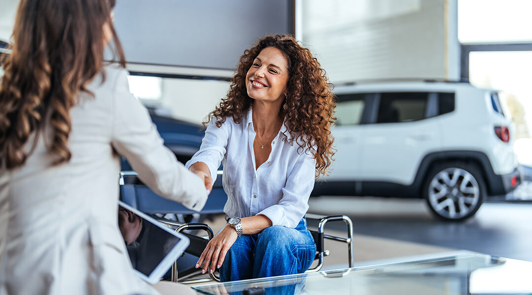 Two women shaking hands in a professional setting.